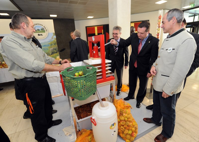Ministerpräsident Mappus, Landwirtschaftsminister Köberle und Landtagsabgeordneter Locherer an einer Rink-Saftpresse (Foto "Staatsministerium")